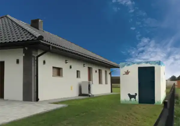 Single-story house with a dark tiled roof and a white yard; a small painted dog house with a blue door sits on the lawn.